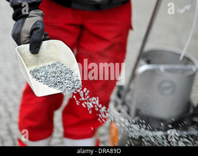 Berlin, Germany. 20th Jan, 2014. An employee of winter maintenance scatters grit on a road in Berlin, Germany, 20 January 2014. Temperatures below zero degrees centigrade caused many roads and sidewalks in Berlin to freeze over. Photo: Ole Spata/dpa/Alamy Live News