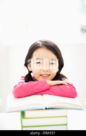a girl leaning on a pile of books under a light bulb Stock Photo - Alamy