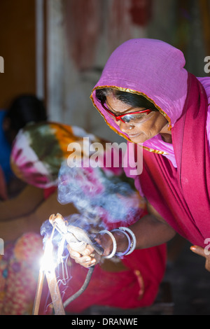 Women welding joints during the construction of solar cookers at the Barefoot College in Tilonia, Rajasthan, India. Stock Photo