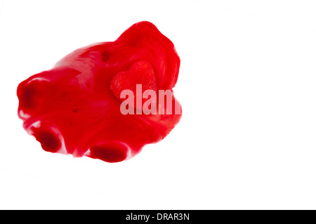 A red ice cube in the shape of a heart melting Stock Photo