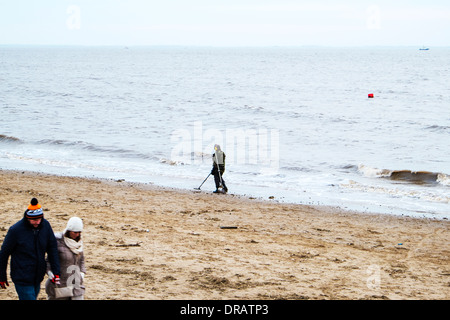 Man using metal detector on beach coast beachcomber Cleethorpes, Lincolnshire coast, UK, England Stock Photo