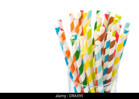 Striped drink straws of different colors in glass isolated on white background Stock Photo