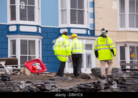 After a week of high tides, storm surges and storm force winds, the sea front promenade of Aberystwyth in Wales has been devastated, with millions of £'s of damage. The crashing waves punched a large hole in the sea wall and has collapsed Aberystwyth's iconic, Victorian promenade shelter, which has stood for over 100 years. This picture was taken on Wednesday 8th January, 2014, the day the council started to try and clear the thousands of tonnes of beach rubble off the sea front road. Stock Photo