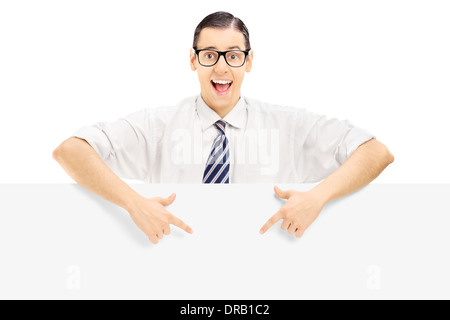 Young man with glasses pointing on a blank panel with both hands Stock Photo