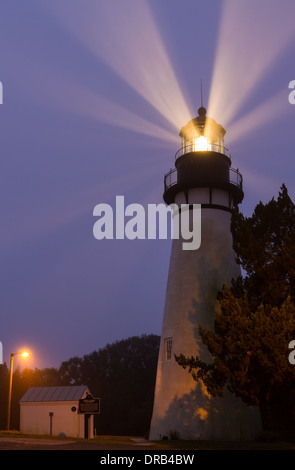 Light beams shine through the fog during the early morning at Amelia Island Lighthouse in Fernandina Beach, Florida. Stock Photo