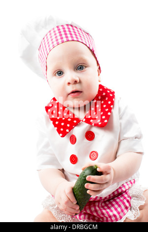 Baby cook girl wearing chef hat with fresh vegetables and fruits. Use it for a child, healthy food concept Stock Photo