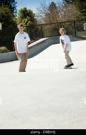 Brothers skateboarding at skatepark Stock Photo
