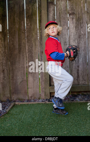 Boy throwing a baseball in the backyard. Stock Photo