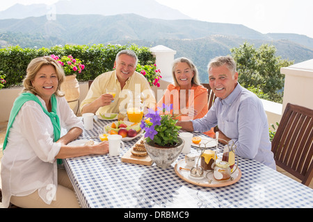 Senior couples enjoying breakfast on patio Stock Photo