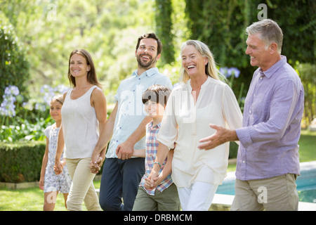 Multi-generation family walking in backyard Stock Photo