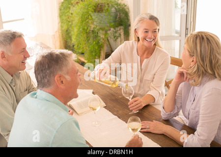 Senior couples drinking wine at dining table Stock Photo