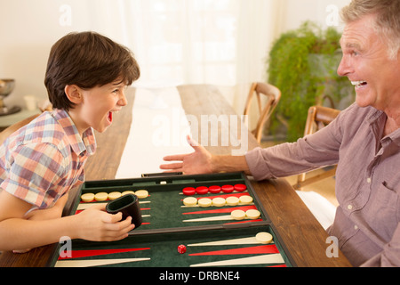 Grandfather and grandson playing backgammon Stock Photo