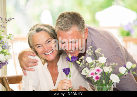 Senior couple smelling flowers Stock Photo