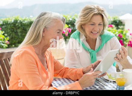 Senior women using digital tablet at patio table Stock Photo