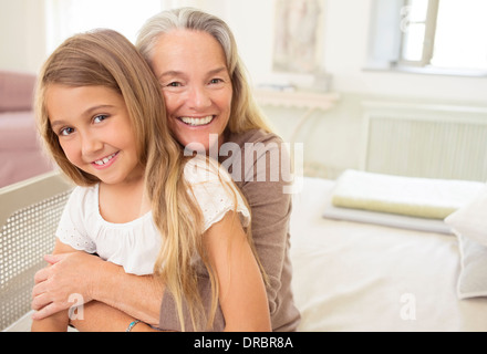 Grandmother hugging granddaughter Stock Photo