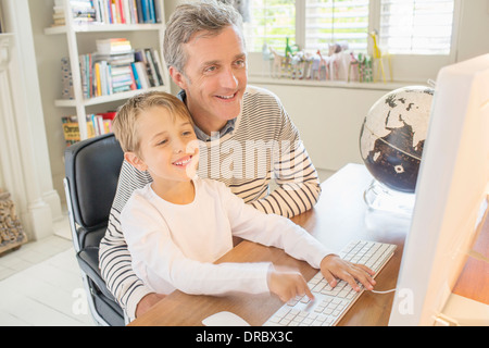 Father and son using computer together Stock Photo