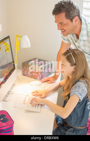 Father and daughter using computer together Stock Photo