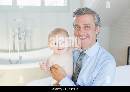 Father holding baby in bathroom Stock Photo