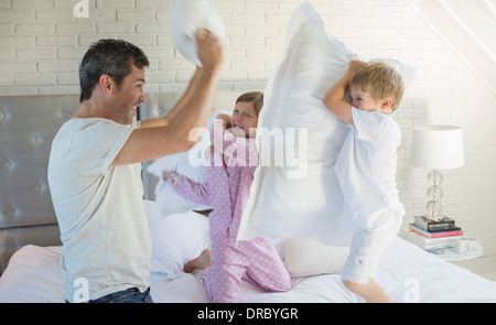 Father and children having pillow fight Stock Photo