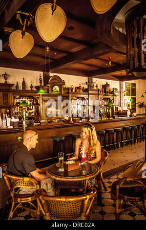 Couple siting in the Long Bar of Raffles Hotel in Singapore Stock Photo