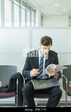 Businessman looking at resume in waiting area Stock Photo