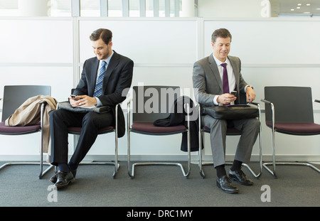 Businessmen sitting in waiting area Stock Photo