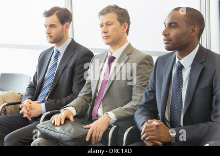 Businessmen sitting in waiting area Stock Photo