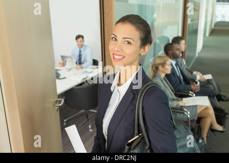 Businesswoman smiling in office doorway Stock Photo