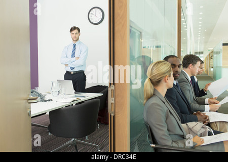 Businessman standing in office and business people in corridor Stock Photo