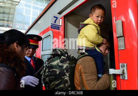 Kunming, China's Yunnan Province. 23rd Jan, 2014. A man carrying a boy boards a train at the Kunming Railway Station in Kunming, capital of southwest China's Yunnan Province, Jan. 19, 2014. China has kicked off its annual Lunar New Year travel rush period, with more than 3.62 billion trips expected to be made on roads, and via trains, planes and ships around the Spring Festival, which falls on Jan. 31 this year. Credit:  Wang Jianyun/Xinhua/Alamy Live News Stock Photo