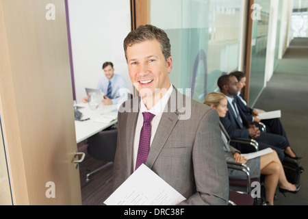 Businessman smiling in office Stock Photo