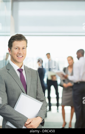 Businessman smiling in office Stock Photo