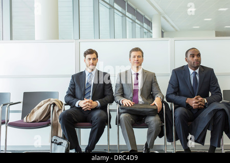 Businessmen sitting in waiting area Stock Photo