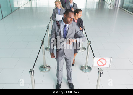 Businessman waiting in line Stock Photo
