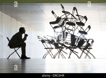 Businessman viewing office chair installation art Stock Photo