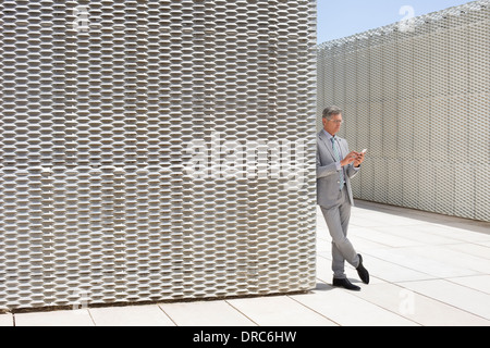 Businessman using cell phone outdoors Stock Photo