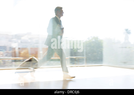 Businessman running in sunny airport Stock Photo