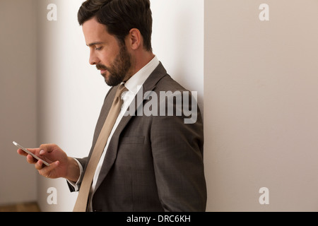 Businessman using cell phone in office Stock Photo