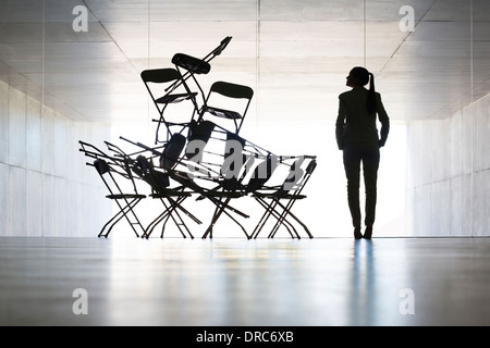 Businesswoman examining office chair installation art Stock Photo