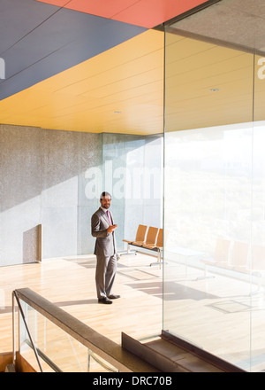 Businessman smiling in sunny office lobby Stock Photo