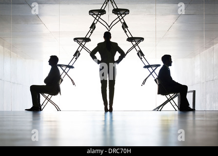 Businesswoman examining office chair installation art Stock Photo