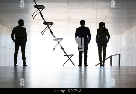 Business people standing next to office chair installation art Stock Photo