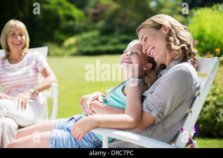 Mother and daughter relaxing in backyard Stock Photo