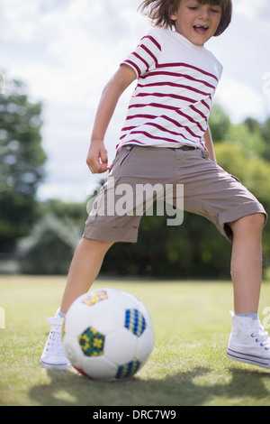 Boy playing soccer outdoors Stock Photo