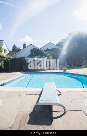 Diving board at edge of swimming pool Stock Photo