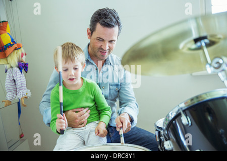 Father and son playing drums together Stock Photo