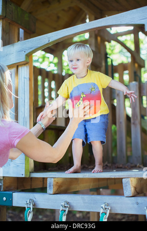 Boy jumping from playset into father's arms Stock Photo