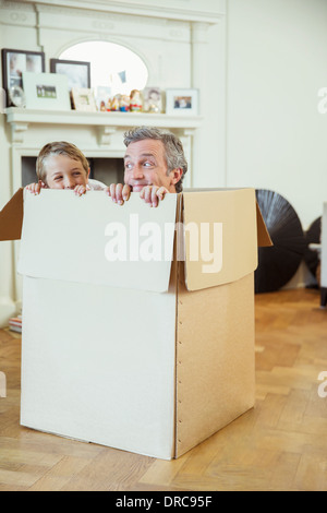 Father and son playing in cardboard box Stock Photo