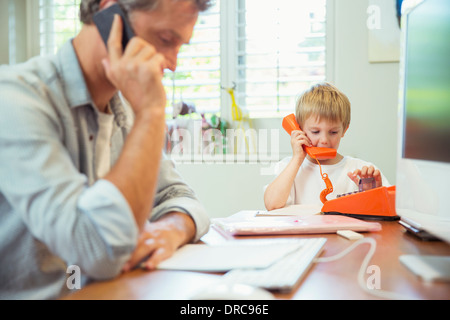 Father and son working in home office Stock Photo