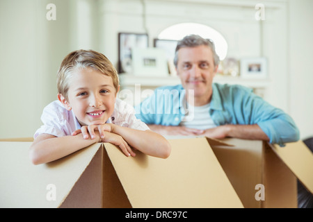 Father and son playing in cardboard boxes Stock Photo